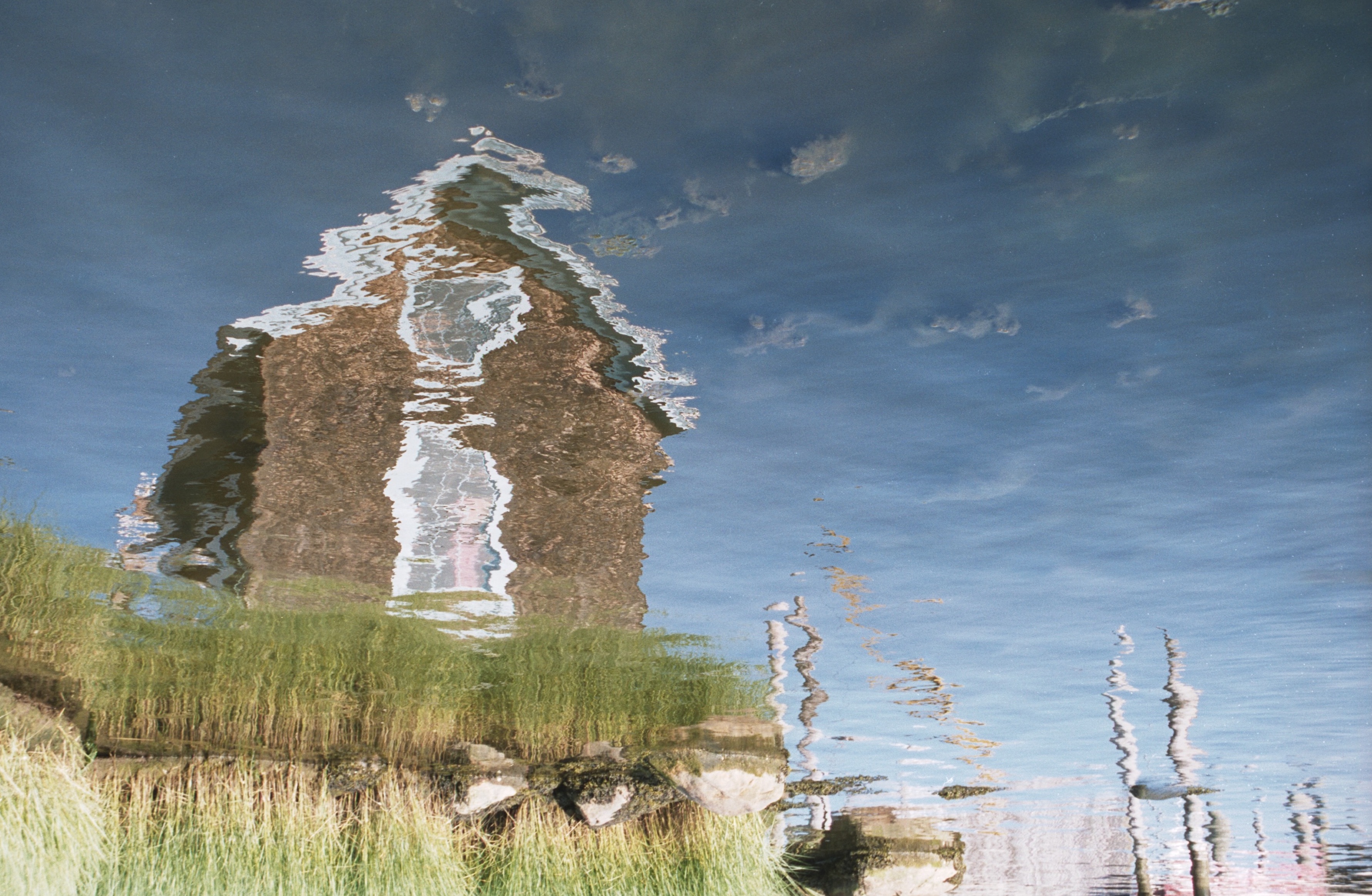 reflection of a boathouse in water