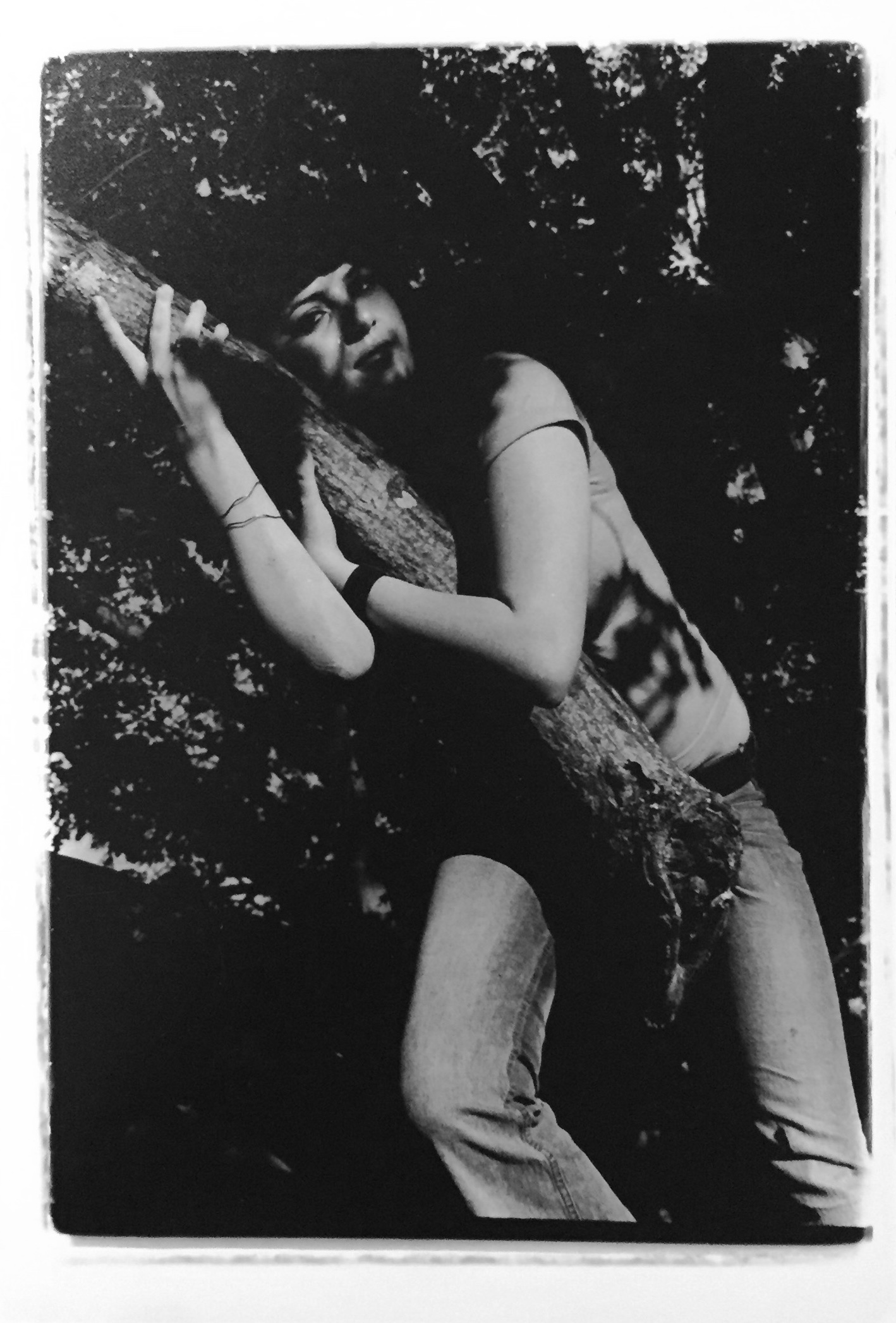 black and white photograph of a girl in a tree