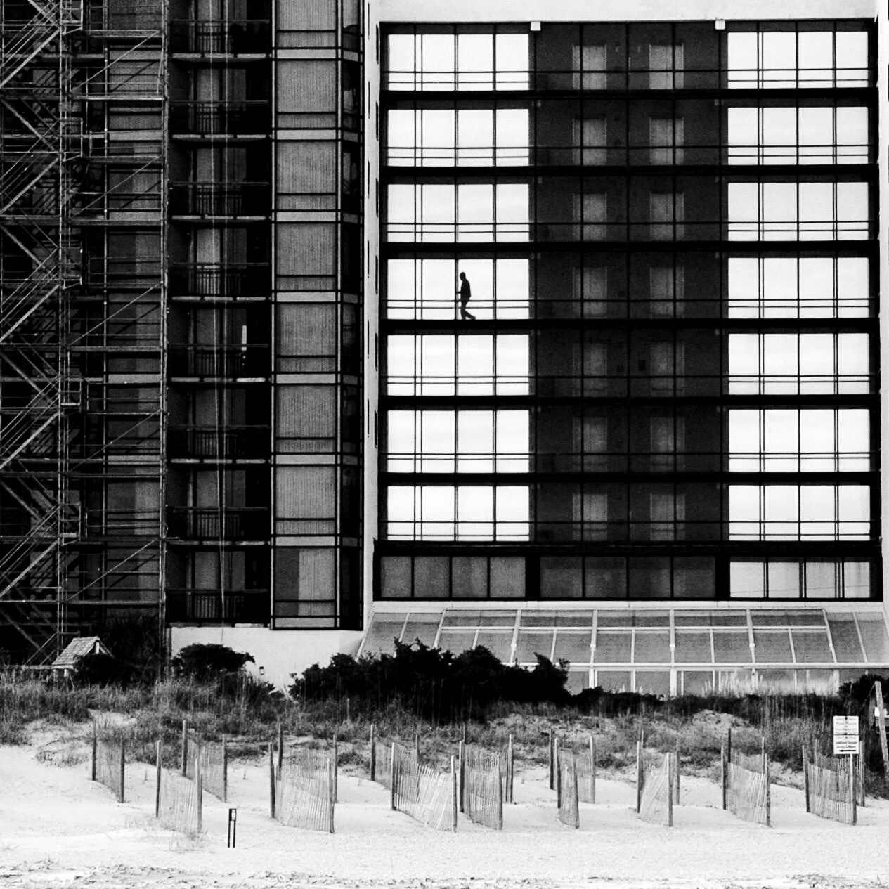 black and white photograph of a hotel on a beach