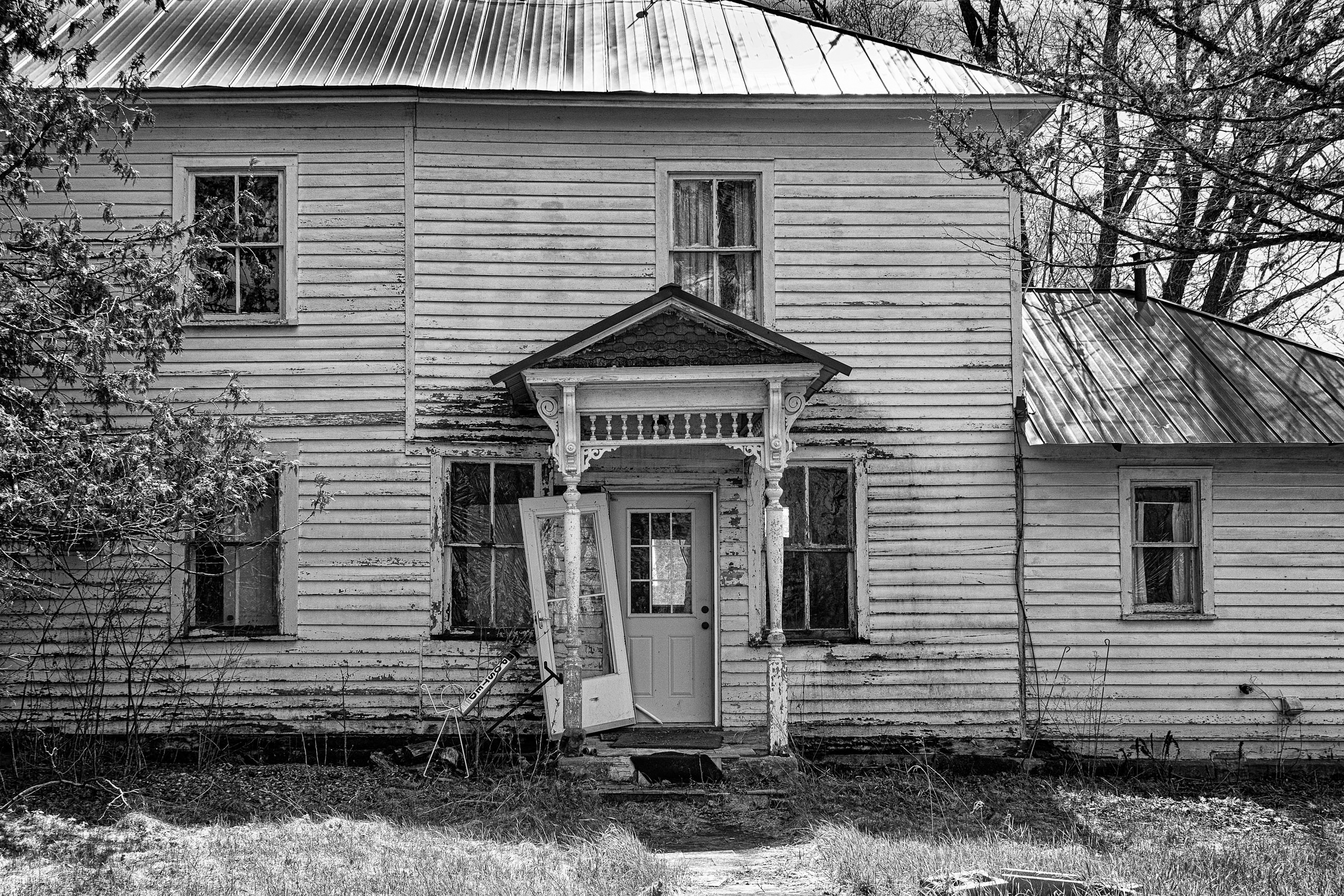 black and white photograph of a rundown house
