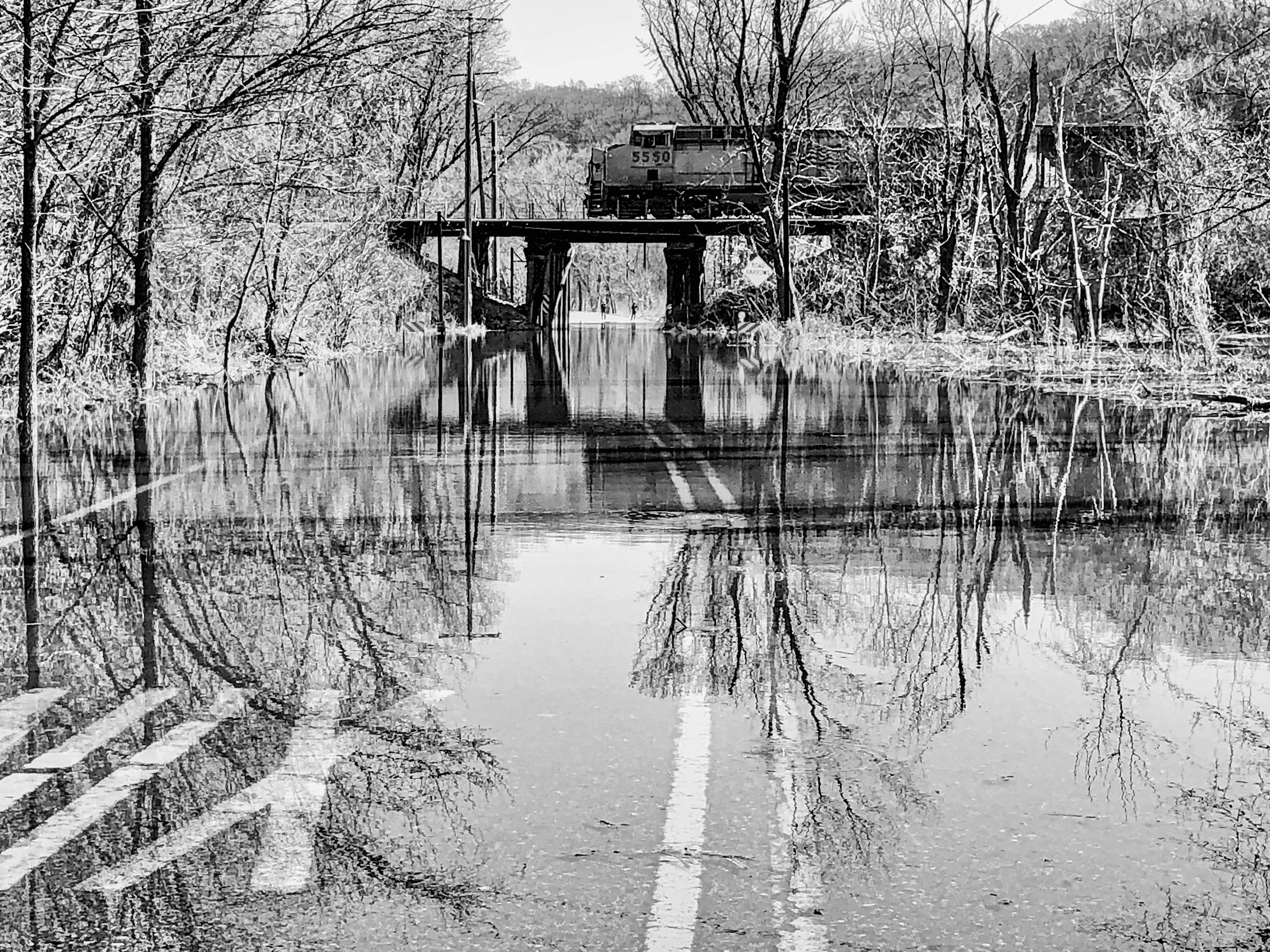 black and white photograph of a train on a bridge